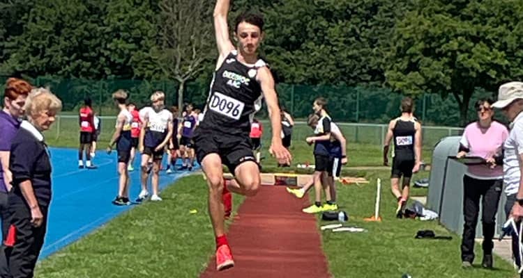 Teenage boy doing long jump in Deeside